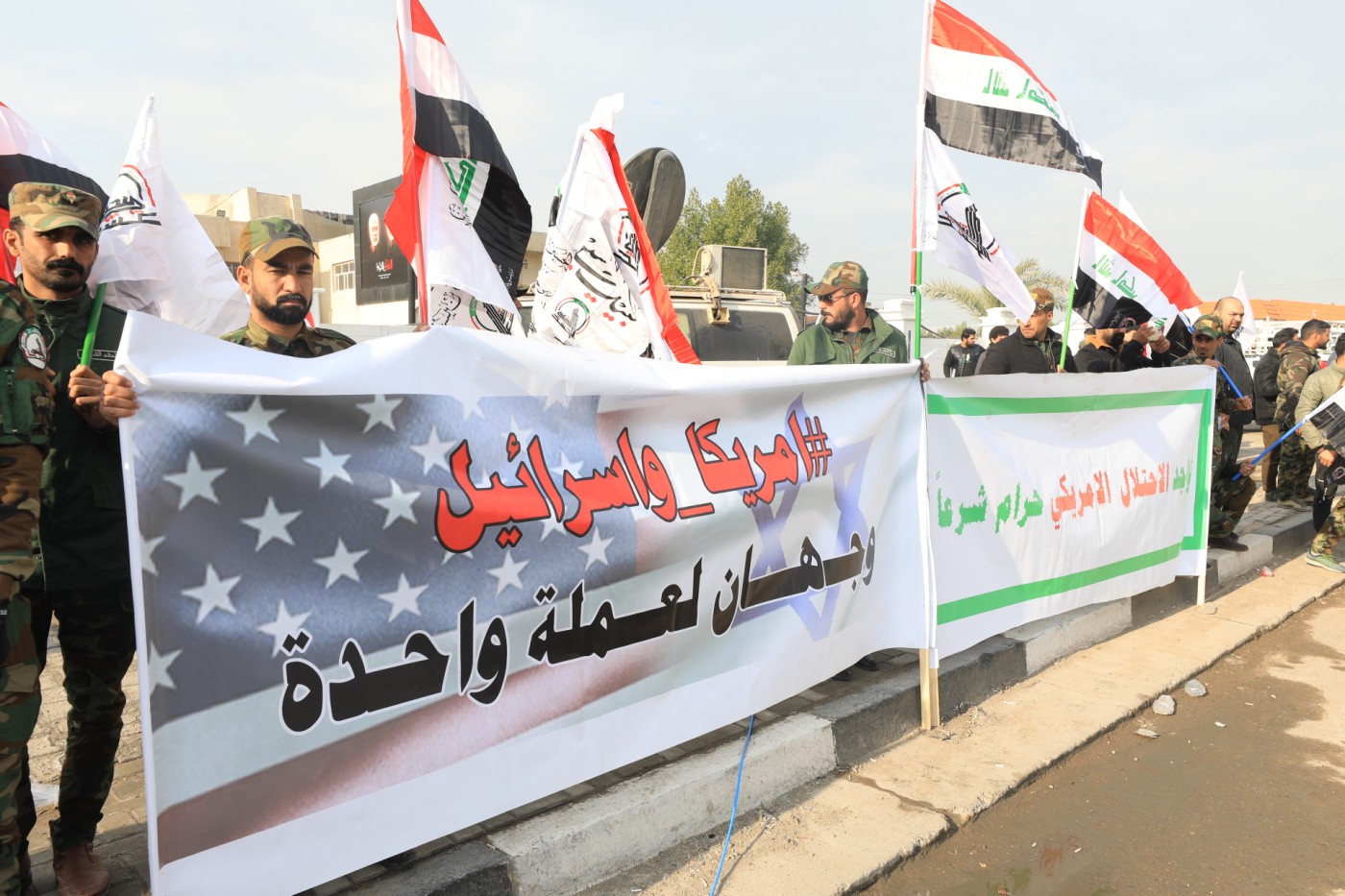 Image of PMF leaders and followers march through Baghdad in honor of PMF militants killed in the Friday US strikes on al-Qaem