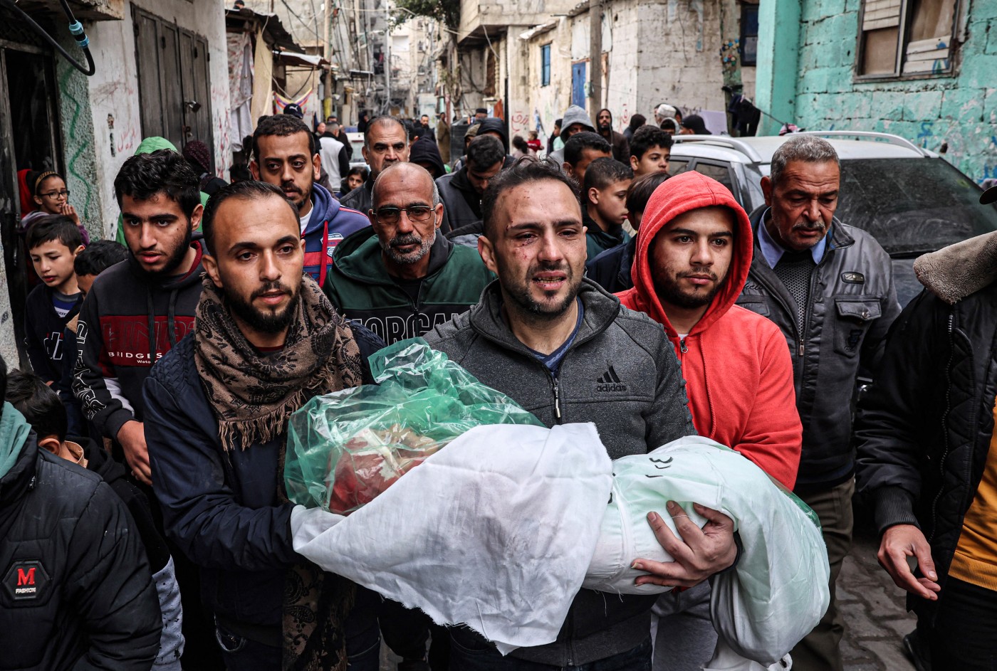 Image of  Father carries slain daughter's body amid ongoing clashes in Gaza